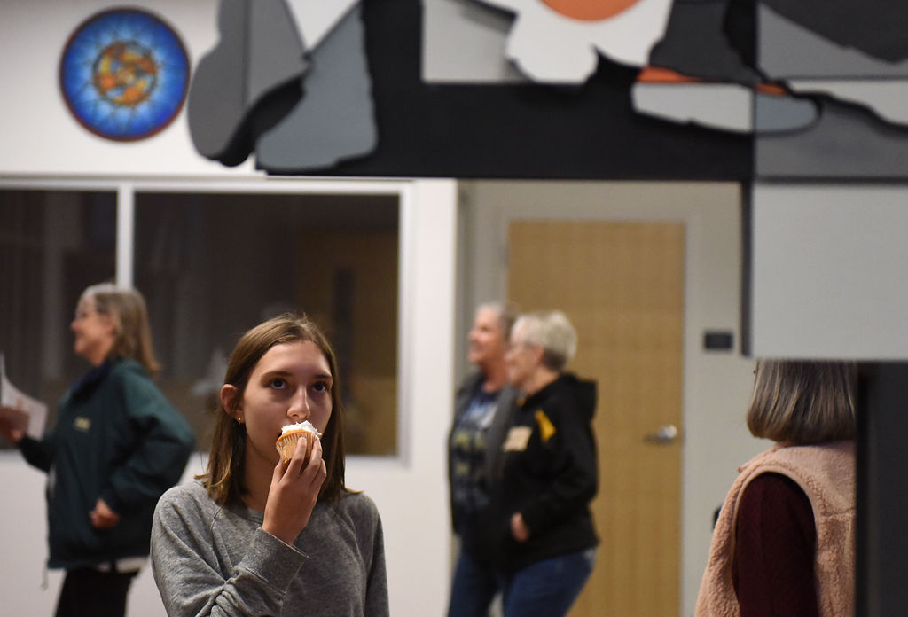 Sofia Heredia eats a cupcake and looks at artwork on display after a dedication ceremony for the new Columbia Sports Fieldhouse